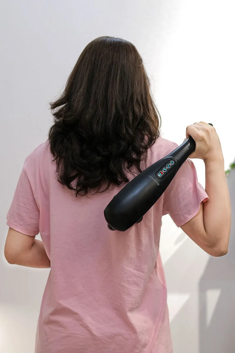 cô gái đang sử dụng máy massage cầm tay KINGTECH LUX-900